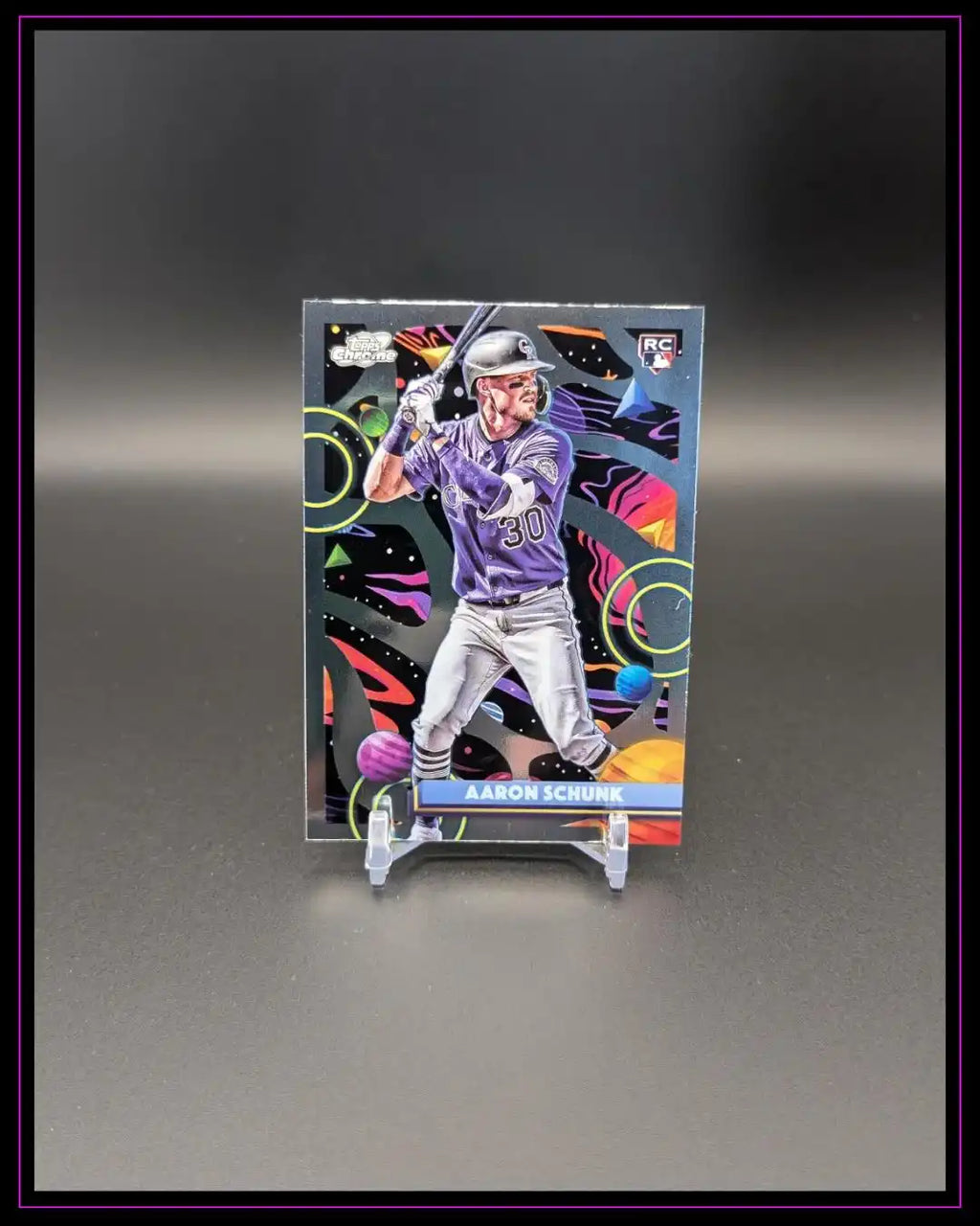 Baseball Trading Card mit Spieler in lila Trikot, bunter Hintergrund, auf Ständer präsentiert