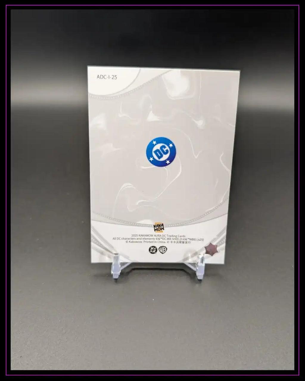 Rückseite einer DC Trading Card mit Logo, auf Kartenständer vor neutralem Hintergrund