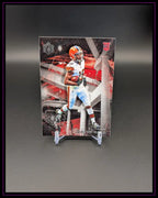 NFL Football Trading Card mit Spieler in braun-weißer Uniform und Rookie-Emblem, schwarz-roter Hintergrund