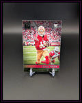 Football Rookie Trading Card mit Spieler im rot-goldenen Trikot auf schwarzem Ständer