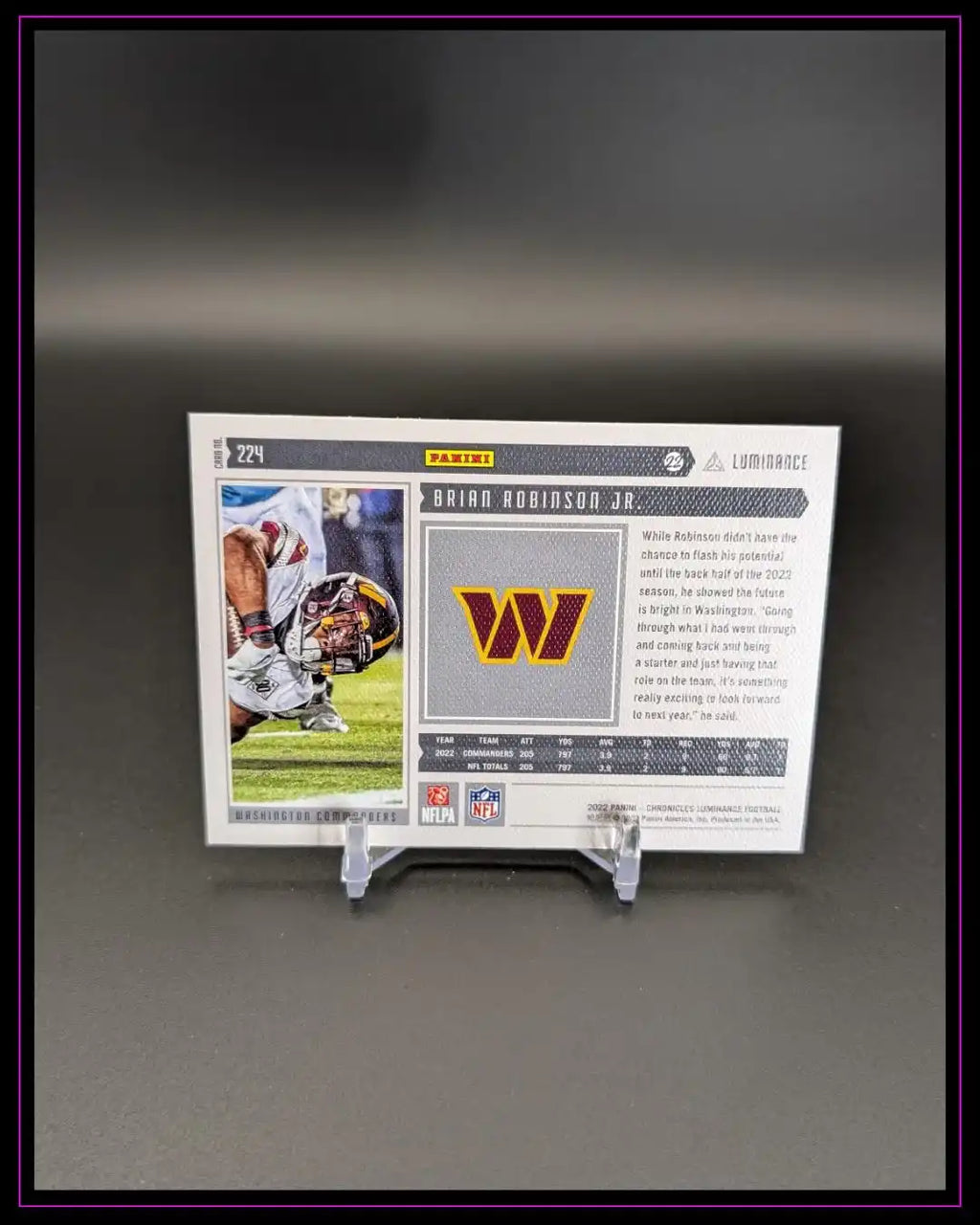 Rückseite einer Panini Football Trading Card von Brian Robinson Jr., Washington Commanders, auf Kartenständer.