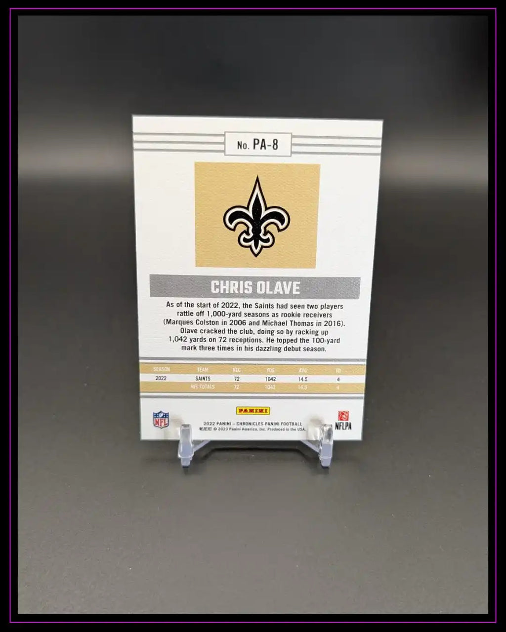 Rückseite einer NFL Chris Olave Trading Card auf Ständer, Statistiken und Saints-Logo sichtbar